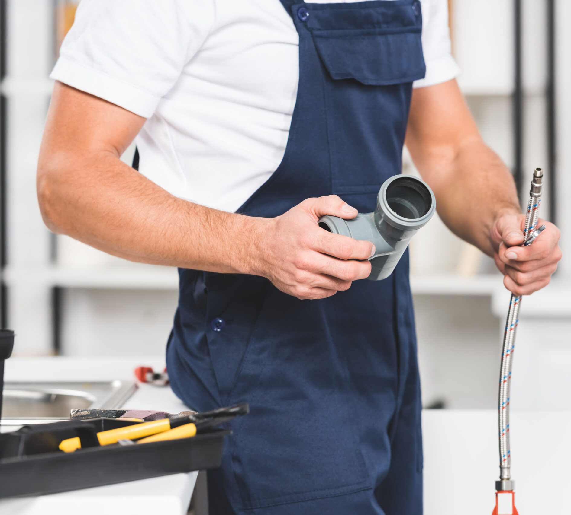 Installateur bei Wartungsarbeiten mit Ersatzrohrverbindung in der Hand - stern-installateur.at